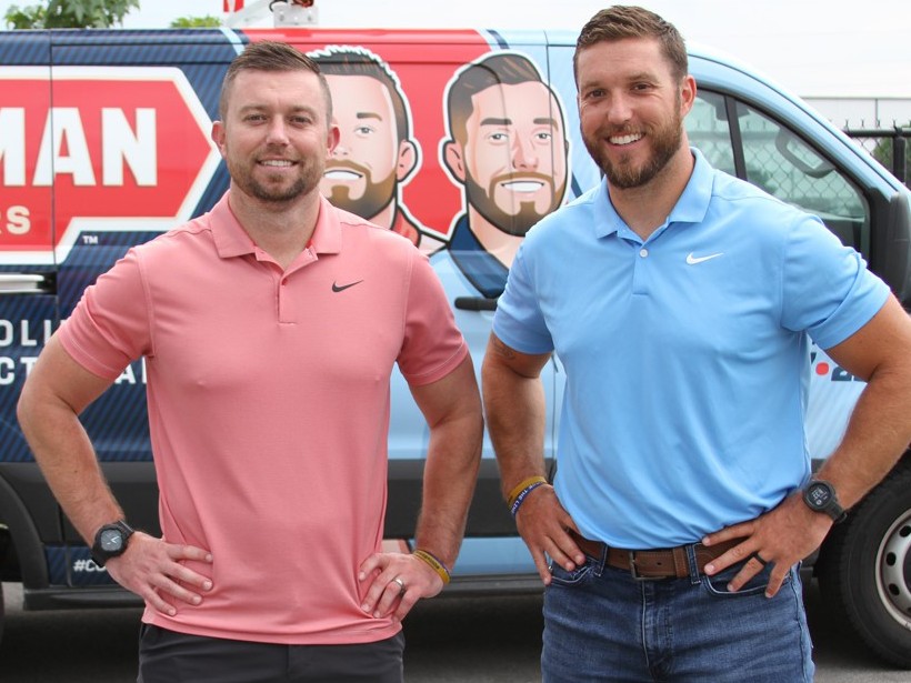 Chad and Tyler Peterman standing in front of a Peterman Brothers van